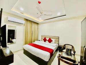 a bedroom with a large bed with red pillows at Hotel The Lycoris - A Corporate and couple friendly hotel in Chandīgarh