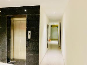 a hallway with black tile and a elevator at Hotel The Lycoris - A Corporate and couple friendly hotel in Chandīgarh