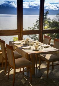 a dining room table with chairs and a large window at Park Lake Luxury Hotel in Pucón