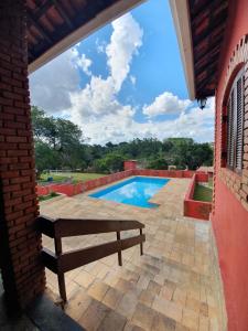 un patio con banco y piscina en Chácara guararema, en Guararema
