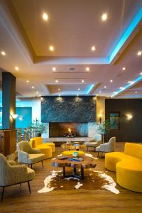 - un hall doté d'un mobilier jaune et d'une cheminée dans l'établissement Park Lake Luxury Hotel, à Pucón
