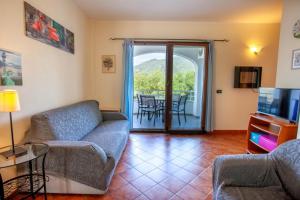 Le Residenze Blu Sardinia في لا كاليتا: غرفة معيشة مع أريكة وتلفزيون