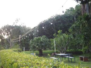 een groep tafels en stoelen in een park met bomen bij Yura Kiri Resort Khao Yai in Mu Si