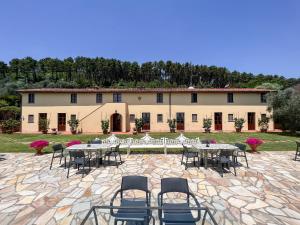 a group of tables and chairs in front of a building at Agriturismo Cima alla Serra in Buti