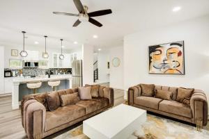 a living room with two couches and a kitchen at Chic and Spacious West Dallas Home Near Downtown! in Dallas