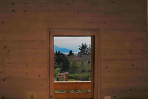 una puerta a una cabaña con vistas a la montaña en Green Chalet Scalotta - Wonderful Terrace Lake and Mounts View en Dervio