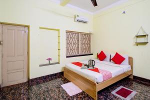 1 dormitorio con 1 cama con almohadas rojas y puerta en Flagship The Buddha Guest House en Behāla