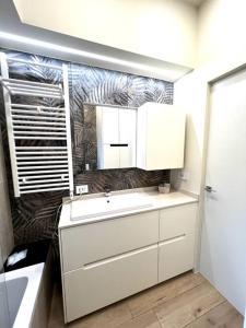 a white bathroom with a sink and a mirror at Home Donatella in Cormano