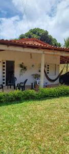una casa con un patio con sillas delante en Casa Viçosa 5km centro, en Viçosa do Ceará