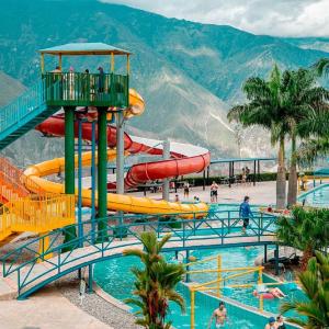 a water park with slides and people in the water at Montañita del Río in Aratoca