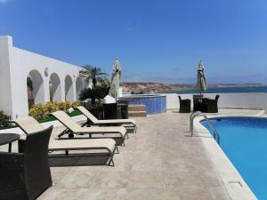 un patio con sillas y una piscina en Panoramic View to the ocean Manta en Manta