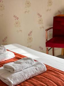 Una cama con toallas y una silla roja. en The Fat Lamb Country Inn and Nature Reserve, en Ravenstonedale
