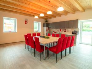 kuchnia z drewnianym stołem i czerwonymi krzesłami w obiekcie Resort U sýrárny w mieście Sobotín