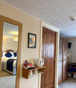 a bedroom with a bed and a door with a mirror at The Fat Lamb Country Inn and Nature Reserve in Ravenstonedale