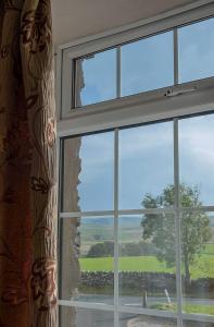une fenêtre avec vue sur un champ verdoyant dans l'établissement The Fat Lamb Country Inn and Nature Reserve, à Ravenstonedale