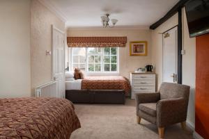 um quarto com uma cama, uma janela e uma cadeira em Springfield House - Birmingham Airport & NEC em Coleshill