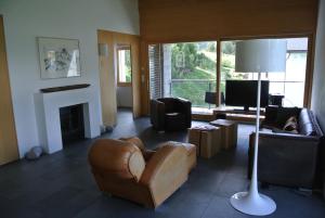 a living room with a couch and a fireplace at Chesa La Montanella - Ferienwohnung, Maloja in Maloja