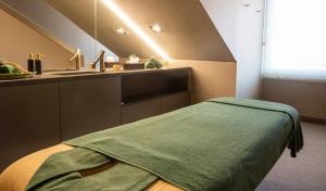 una camera da letto con lavandino e un letto con una coperta verde di Figueira by The Beautique Hotels & Spa a Lisbona