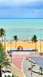 vistas a una playa con palmeras y al océano en Flat Atlântico Tambaú, en João Pessoa