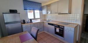 a kitchen with white appliances and a table and a tableablish at Ferienwohnung S-Bahn Nähe in Schwaikheim