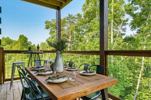 uma mesa de madeira com cadeiras e um vaso no deque em Modern Pool Cabin, Hot Tub, Pet Friendly, Secluded, Mins to Wilderness em Sevierville