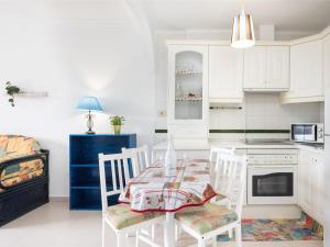 een keuken met witte kasten en een tafel en stoelen bij Live Balcon del Mar in Costa Del Silencio +14 foto's