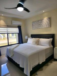 Schlafzimmer mit einem großen Bett und einem Deckenventilator in der Unterkunft Lovely Memories Vacation Home in Ocho Rios
