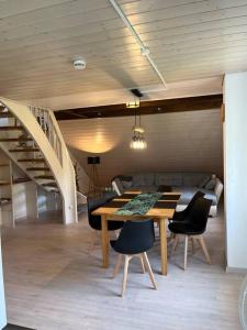 ein Esszimmer mit einem Tisch, Stühlen und einer Treppe in der Unterkunft Löwen Appartement in Hausach