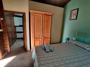 1 dormitorio con cama y armario de madera en Casa Rural en Yeguada Vistabella., en Enguera