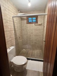 uma casa de banho com um WC e um chuveiro com uma janela em Villaggio Zamprogno em Santa Teresa