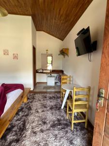 um quarto com uma mesa e uma cama e uma televisão em Villaggio Zamprogno em Santa Teresa