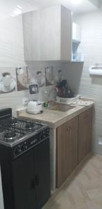 a kitchen with a black stove and a sink at Apartamento vacacional in Girardot