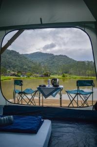 a view from the back of a boat with a table and chairs at Recanto do Vale Glamping in Pomerode