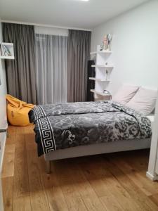 1 dormitorio con 1 cama con manta blanca y negra en Grand Appartement de standing Rooftop Jacuzzi, en Malakoff