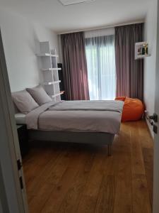 1 dormitorio con 1 cama y suelo de madera en Grand Appartement de standing Rooftop Jacuzzi, en Malakoff