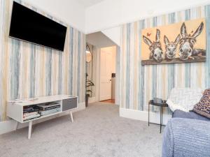 sala de estar con TV de pantalla plana en la pared en Little Polgray en St Austell