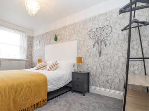 1 dormitorio con 1 cama y un mural en la pared en Little Polgray en St Austell