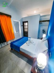 a bedroom with a large bed with blue and orange curtains at Pousada Green Place in Ribeira Grande