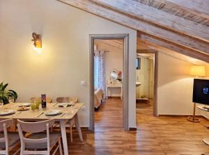 een eetkamer met een tafel en stoelen en een televisie bij Alegria apartments in Gaios