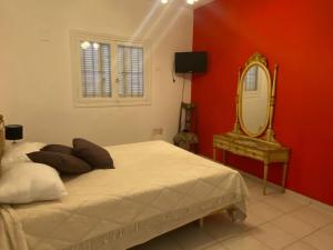 Schlafzimmer mit einem weißen Bett und einem Spiegel in der Unterkunft DEPARTAMENTO VINTAGE 2 HABITACIONES 2 BAÑOS LiVING COMEDOR COCINA A 2 CUADRAS PEATONAL CENTRO SAN JUAN in San Juan