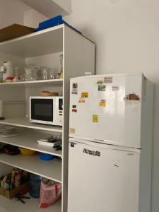 eine Küche mit einem weißen Kühlschrank und einer Mikrowelle in der Unterkunft DEPARTAMENTO VINTAGE 2 HABITACIONES 2 BAÑOS LiVING COMEDOR COCINA A 2 CUADRAS PEATONAL CENTRO SAN JUAN in San Juan