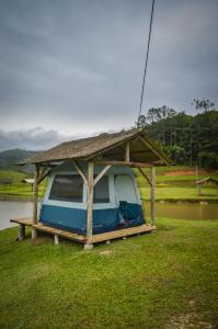 a small boat with a roof on the grass at Recanto do Vale Glamping in Pomerode +17 photos