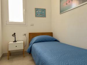ein Schlafzimmer mit einem Bett und einer Lampe auf einem Nachttisch in der Unterkunft Sunnyside Apartment in Torre Grande