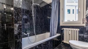 a bathroom with a shower and a tub and a toilet at Grand Central - Affitti Brevi Italia in Modena +32 photos