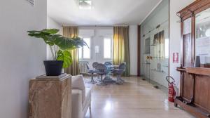 a living room with a couch and a potted plant at Grand Central - Affitti Brevi Italia in Modena
