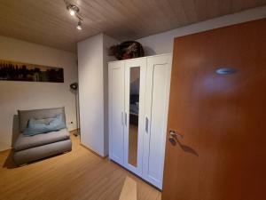 ein leeres Zimmer mit einem Stuhl und einer Tür in der Unterkunft Ferienwohnung Seeblick in Pfullendorf