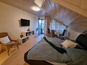 ein Schlafzimmer mit einem großen Bett und ein Wohnzimmer in der Unterkunft Ferienwohnung Seeblick in Pfullendorf