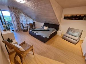 ein Schlafzimmer mit einem Bett und einem Stuhl in einem Zimmer in der Unterkunft Ferienwohnung Seeblick in Pfullendorf