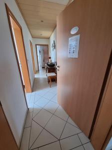 einen Flur mit einer Tür und ein Zimmer mit einem Tisch in der Unterkunft Ferienwohnung Seeblick in Pfullendorf