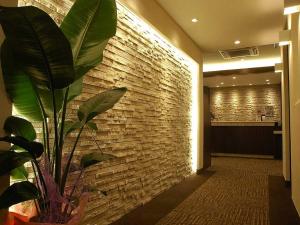 
a room with a wall with a wall with a plant in it at Hotel New Okinawa in Naha
